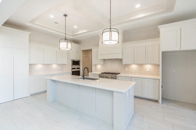 kitchen with sink, appliances with stainless steel finishes, pendant lighting, a kitchen island with sink, and white cabinets