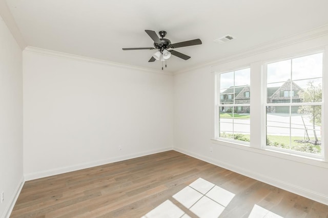 empty room with ornamental molding, light hardwood / wood-style floors, and ceiling fan