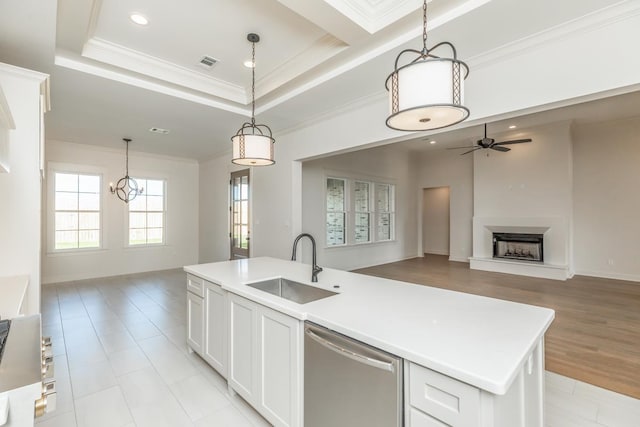 kitchen featuring sink, white cabinetry, hanging light fixtures, dishwasher, and an island with sink