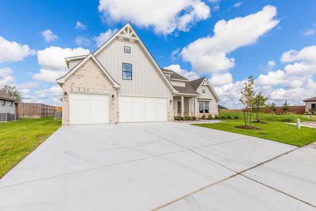 view of front of home featuring central AC, a garage, and a front lawn