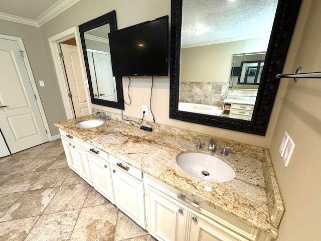 6845 Hialeah Dr, Beaumont, TX 77706 - bathroom with ornamental molding, double vanity, a garden tub, and a textured ceiling