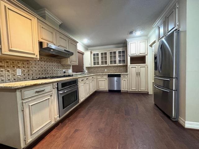 6845 Hialeah Dr, Beaumont, TX 77706 - kitchen with appliances with stainless steel finishes, under cabinet range hood, dark wood-style floors, baseboards, and decorative backsplash