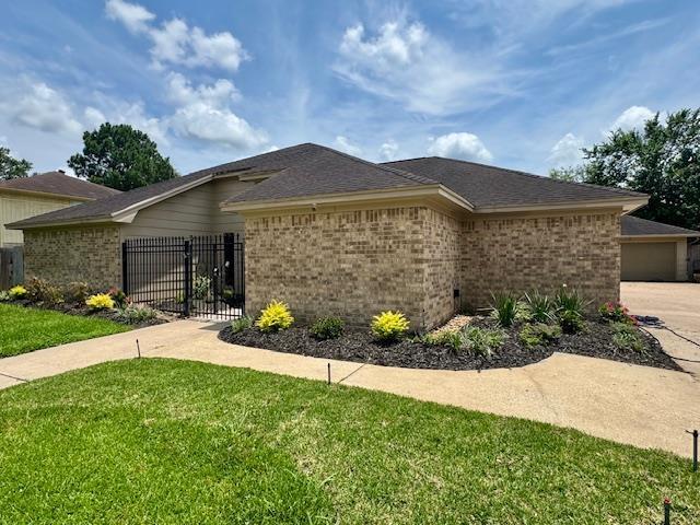 6845 Hialeah Dr, Beaumont, TX 77706 - view of property exterior with brick siding and a gate