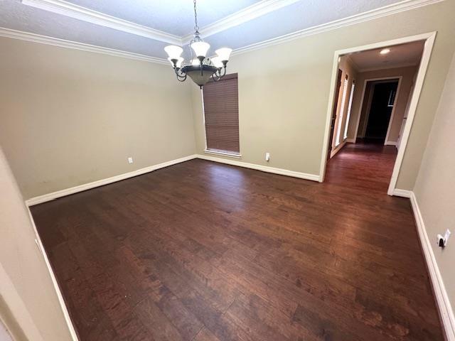 6845 Hialeah Dr, Beaumont, TX 77706 - spare room featuring dark wood-type flooring, a chandelier, baseboards, and crown molding
