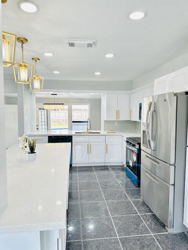 kitchen featuring sink, stainless steel appliances, white cabinets, decorative light fixtures, and kitchen peninsula