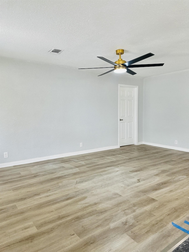 spare room featuring ceiling fan, light hardwood / wood-style flooring, and a textured ceiling