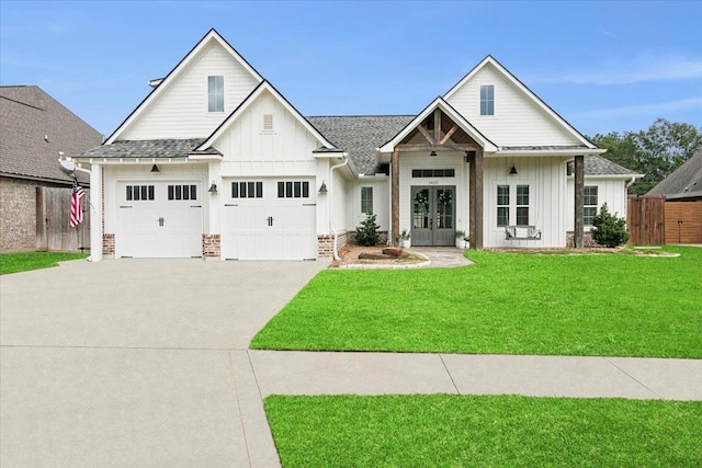 view of front of property with a garage, a front lawn, and french doors