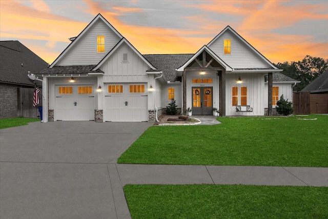 view of front of home with a garage, a yard, and french doors