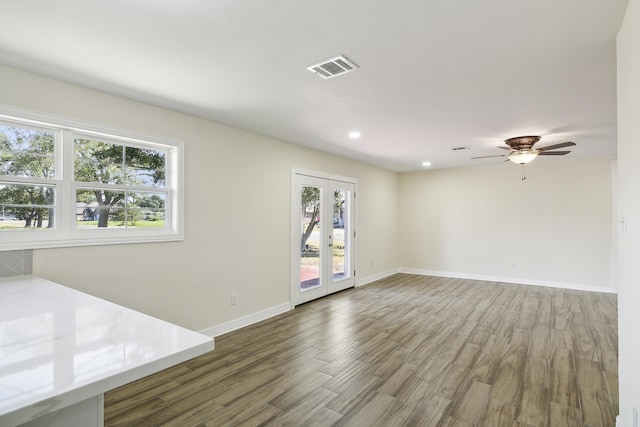 unfurnished living room featuring wood-type flooring, ceiling fan, and french doors