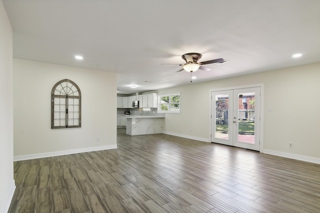 unfurnished living room with ceiling fan, light hardwood / wood-style flooring, and french doors