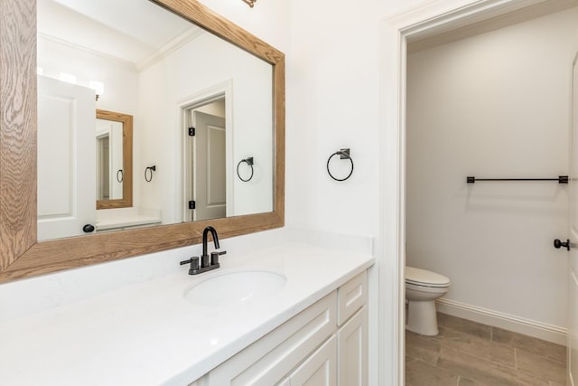 bathroom featuring crown molding, vanity, and toilet