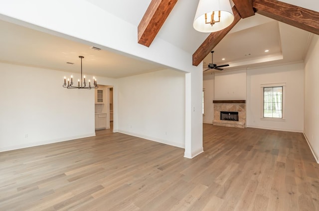 unfurnished living room with beamed ceiling, ornamental molding, and light wood-type flooring