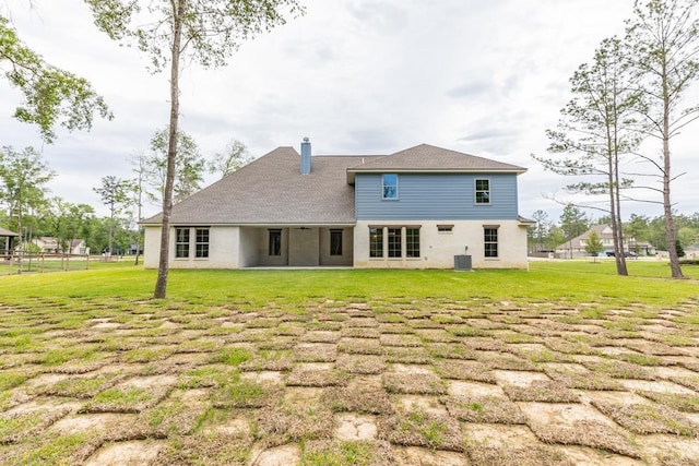 back of house featuring a yard and central air condition unit