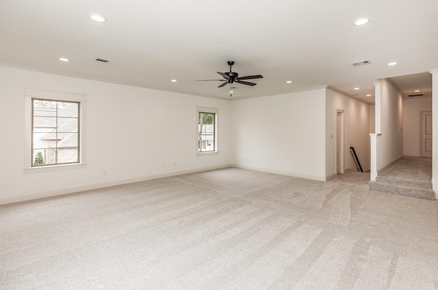 empty room with crown molding, light colored carpet, and ceiling fan