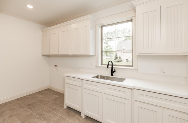 kitchen featuring crown molding, sink, and white cabinets