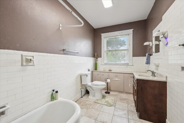 bathroom featuring toilet, tile walls, a tub to relax in, and vanity