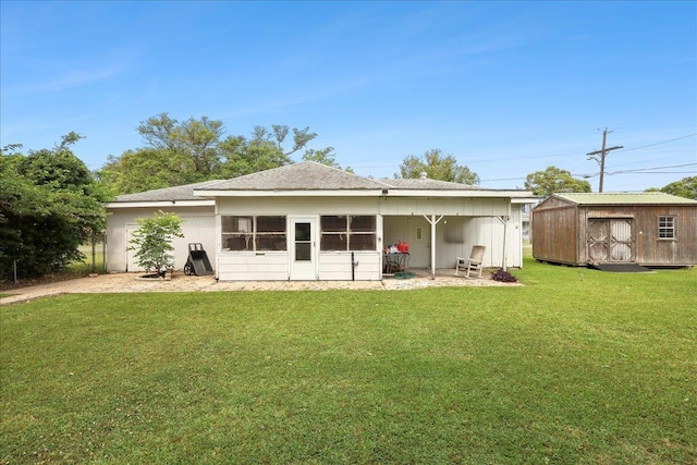 back of house featuring a storage unit, an outdoor structure, and a lawn