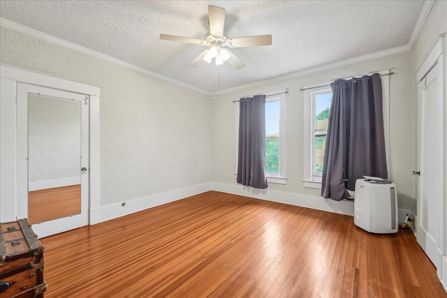 empty room featuring a ceiling fan, a textured ceiling, a textured wall, and hardwood / wood-style flooring