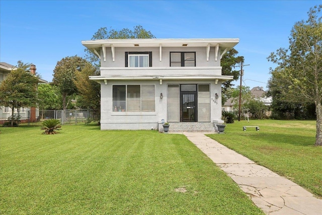 view of front facade featuring stucco siding, a front lawn, and fence