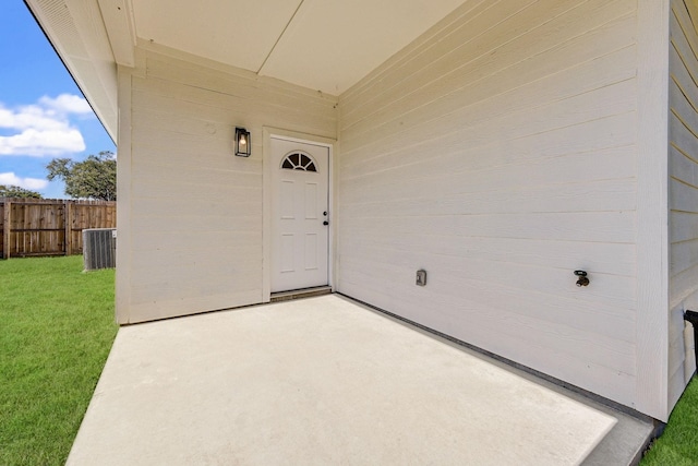 property entrance featuring central AC, a patio area, and a yard