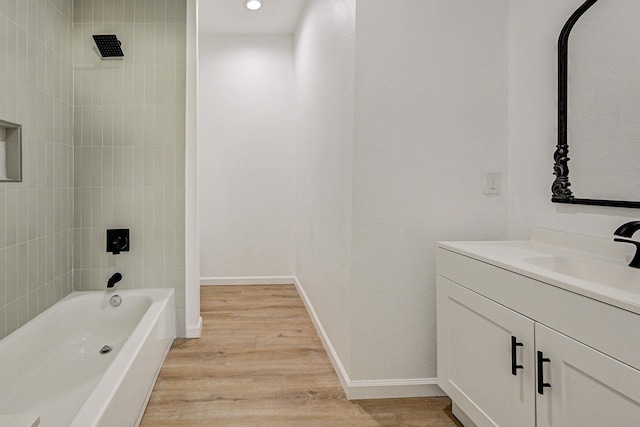 bathroom with vanity, wood-type flooring, and tiled shower / bath combo