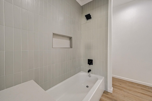 bathroom featuring tiled shower / bath combo and wood-type flooring