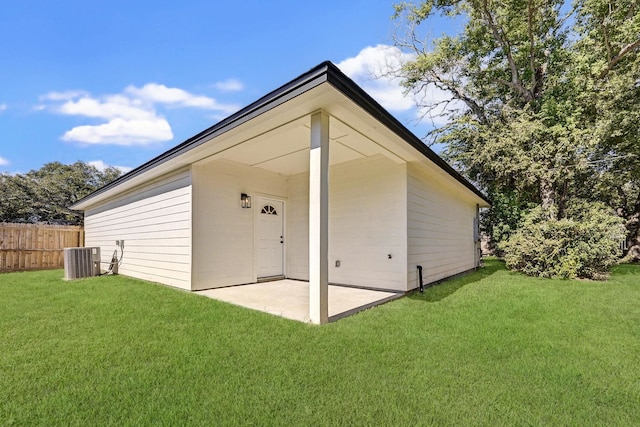 rear view of property with cooling unit and a lawn