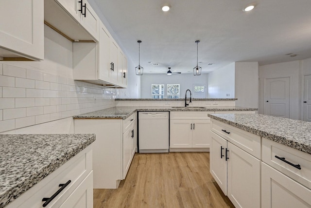 kitchen featuring ceiling fan, sink, hanging light fixtures, tasteful backsplash, and white dishwasher