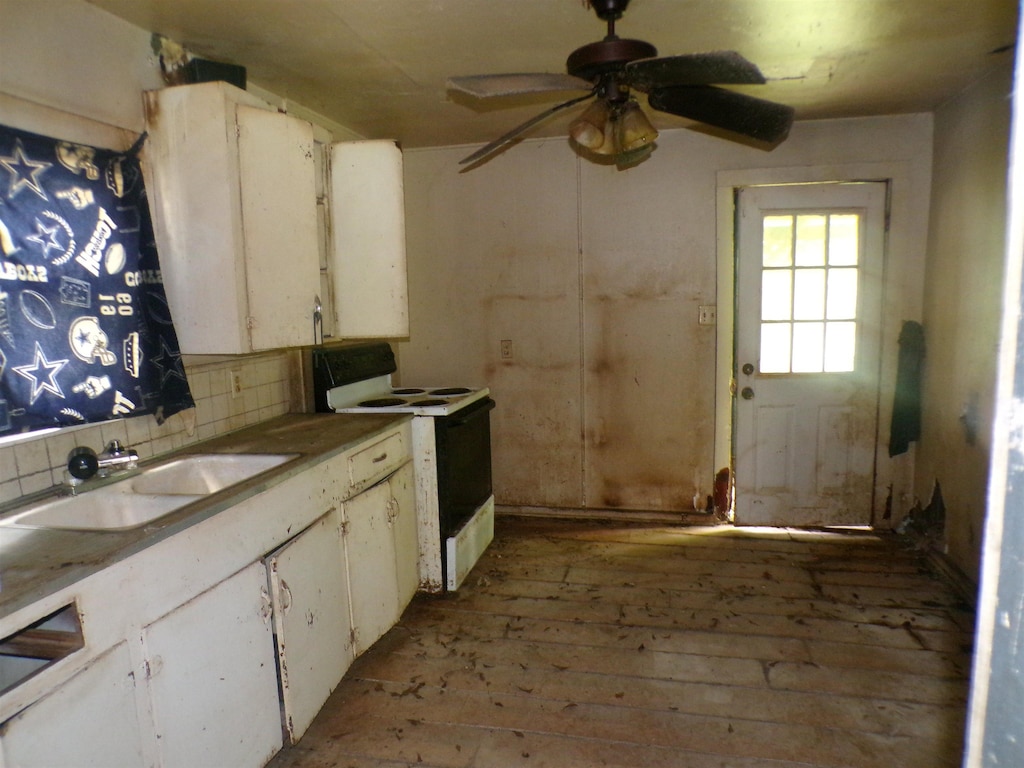 260 S 7th, Silsbee, TX 77656 - kitchen featuring electric stove, a sink, tasteful backsplash, a ceiling fan, and white cabinets