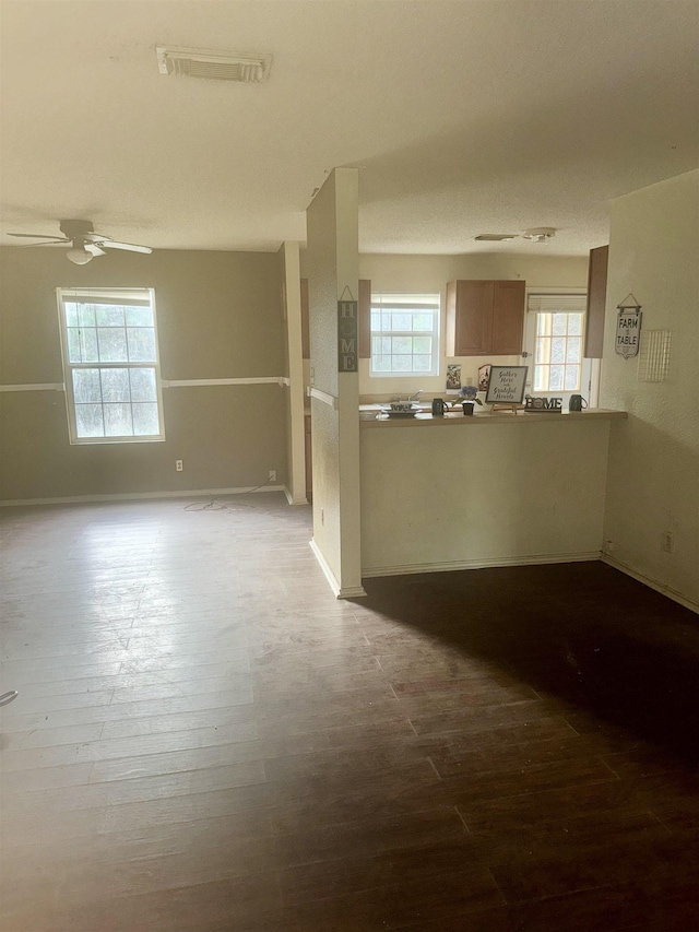 spare room with ceiling fan, a wealth of natural light, and hardwood / wood-style floors