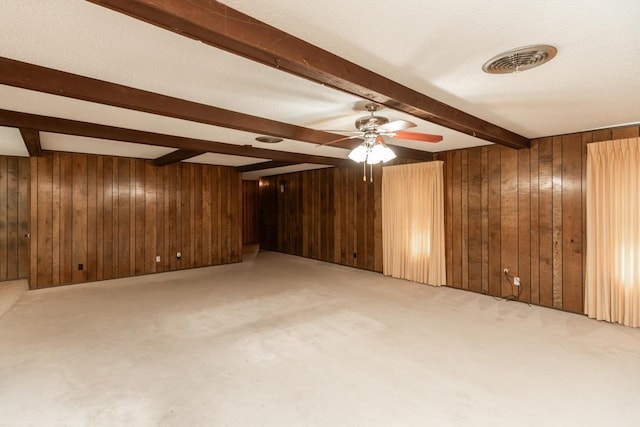 190 Magnolia Trl, Lumberton, TX 77657 - empty room featuring beamed ceiling, wood walls, ceiling fan, and light colored carpet