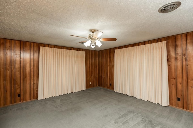 190 Magnolia Trl, Lumberton, TX 77657 - spare room featuring carpet, ceiling fan, wood walls, and a textured ceiling