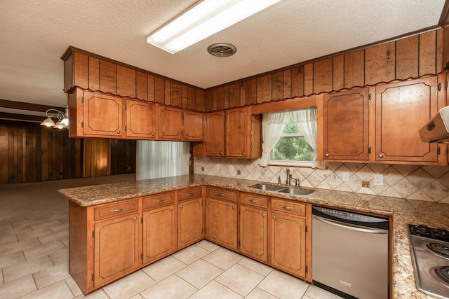 190 Magnolia Trl, Lumberton, TX 77657 - kitchen with appliances with stainless steel finishes, brown cabinets, wood walls, a peninsula, and a textured ceiling