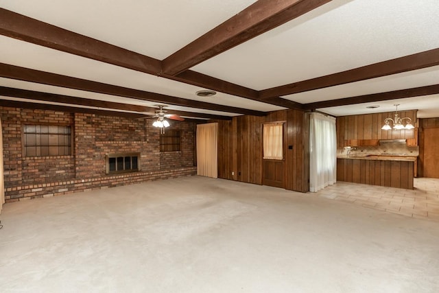 190 Magnolia Trl, Lumberton, TX 77657 - unfurnished living room featuring beamed ceiling, a fireplace, wooden walls, light colored carpet, and brick wall
