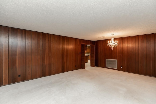 190 Magnolia Trl, Lumberton, TX 77657 - carpeted empty room with a chandelier, a textured ceiling, and wooden walls
