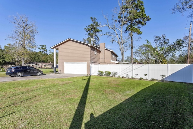 view of side of home featuring a garage, a lawn, driveway, and fence