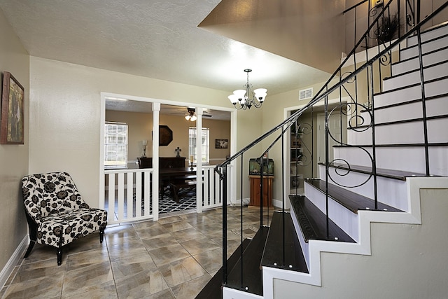 11 Finwick Dr, Orange, TX 77632 - foyer entrance featuring a textured ceiling, ceiling fan with notable chandelier, visible vents, baseboards, and stairway