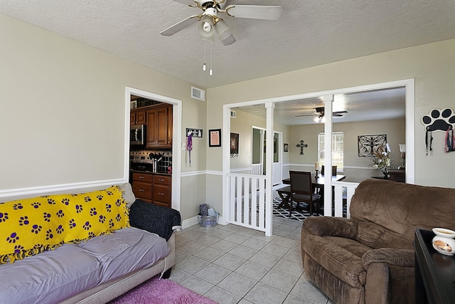 11 Finwick Dr, Orange, TX 77632 - living area featuring visible vents, a ceiling fan, light tile patterned flooring, a textured ceiling, and ornate columns