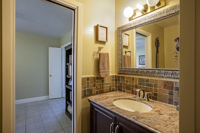 11 Finwick Dr, Orange, TX 77632 - bathroom with baseboards, decorative backsplash, tile patterned floors, a textured ceiling, and vanity