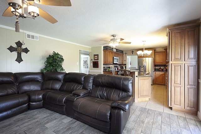 11 Finwick Dr, Orange, TX 77632 - living room with visible vents, a ceiling fan, crown molding, a textured ceiling, and light wood-type flooring