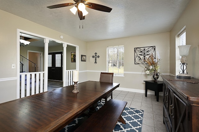 11 Finwick Dr, Orange, TX 77632 - dining area featuring decorative columns, light tile patterned floors, a ceiling fan, a textured ceiling, and baseboards