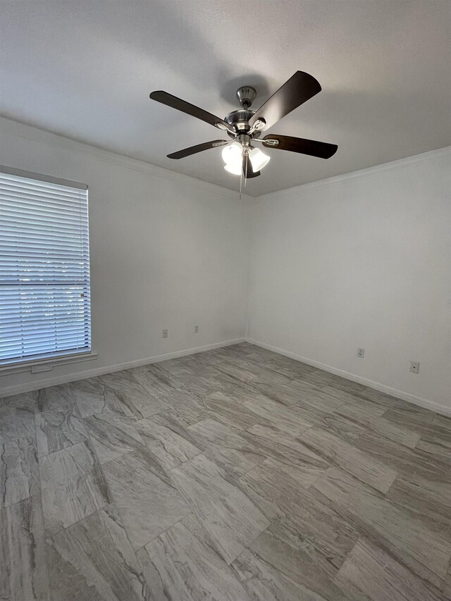 empty room with ceiling fan and ornamental molding