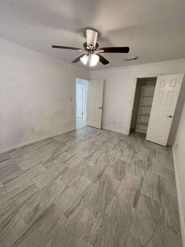 unfurnished bedroom with ceiling fan and a closet