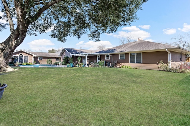 view of front of property with an outdoor pool, a chimney, and a front lawn