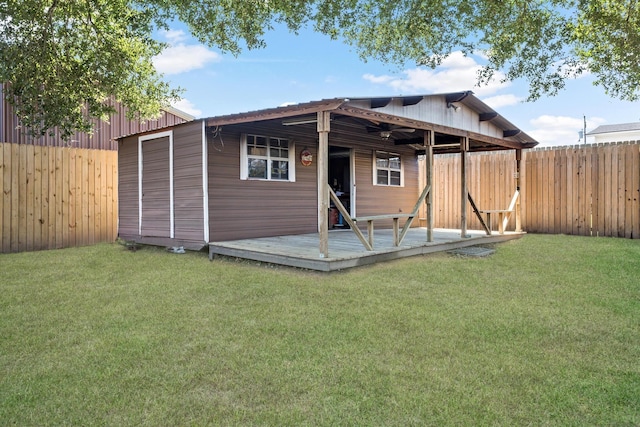 back of house with a fenced backyard, a deck, and a lawn