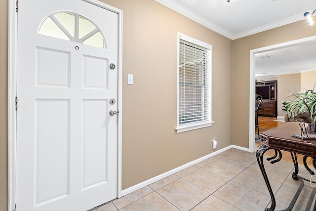 foyer with baseboards, ornamental molding, and light tile patterned flooring