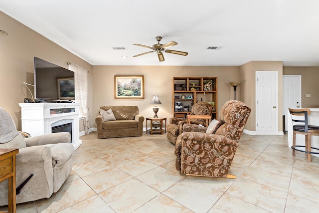 living area featuring ceiling fan, visible vents, and baseboards