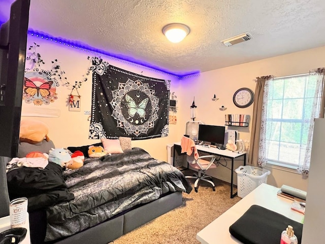 bedroom with multiple windows, carpet floors, and a textured ceiling