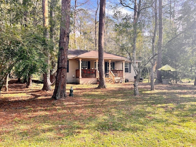 ranch-style home featuring covered porch and a front lawn