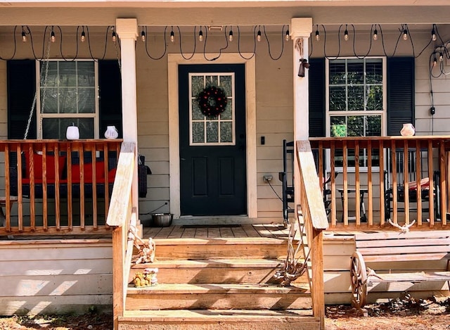 view of exterior entry featuring covered porch